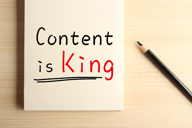 Text Content is King with underline on the notebook with a pencil aside.